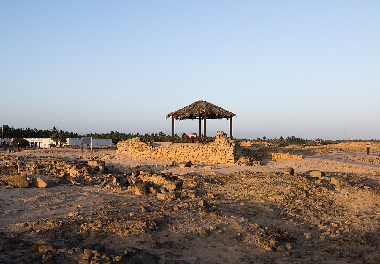 Niedrige Mauerreste und überdachter Rastplatz im archäologischen Park Al Baleed