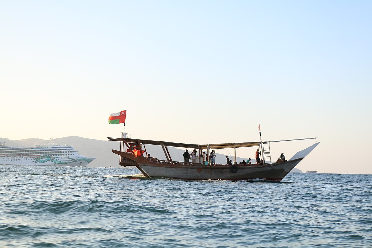 Traditionelle Dhau mit omanischer Flagge auf dem Meer bei Khasab