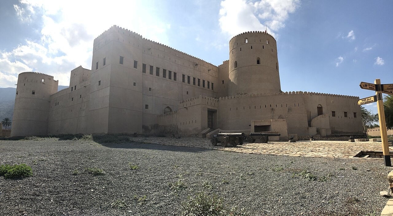 Hohe Mauern und runde Wehrtürme der Festung Rustaq