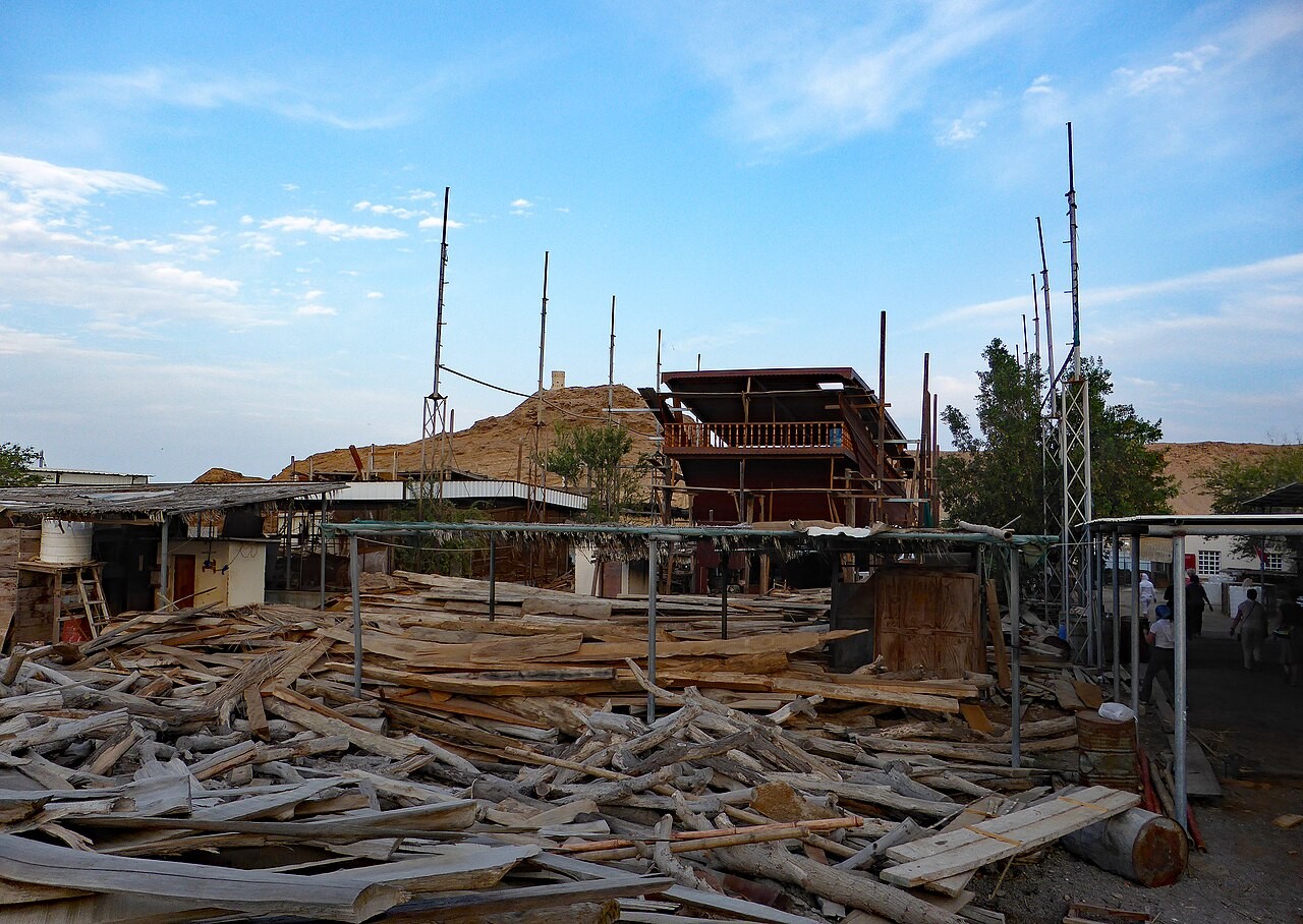 Holzschiff im Bau zwischen Planken und Gerüsten in der Dhau-Werft von Sur